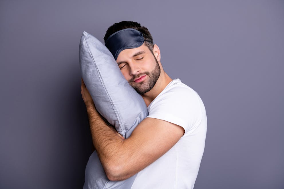 sleep mask, man, and pillow