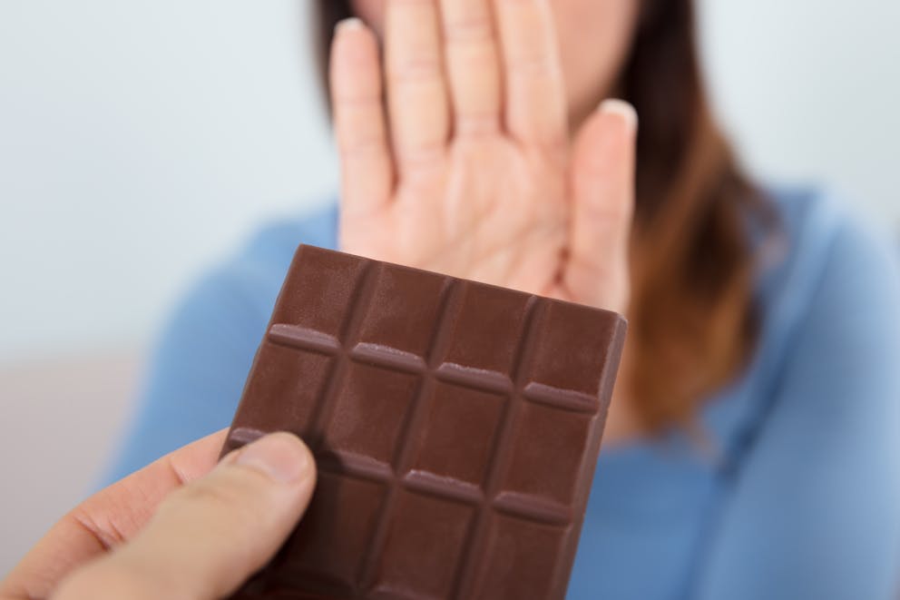Woman rejecting chocolate bar