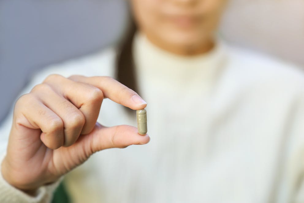 Woman holding sea kelp capsule