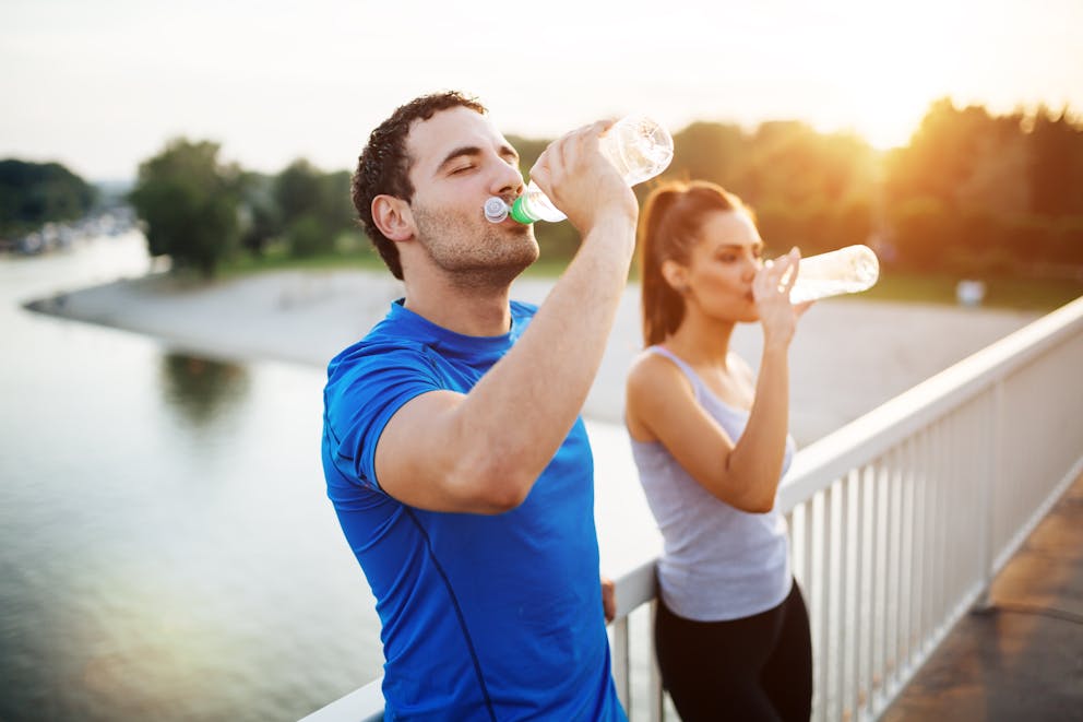 Workout couple drinking from bottles