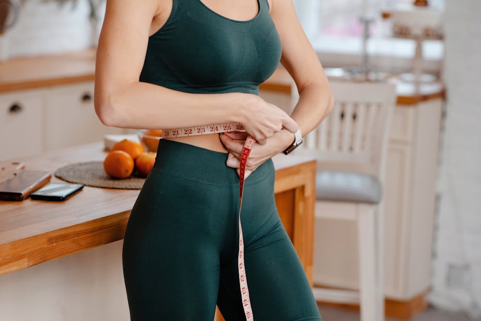 Woman measuring her waist