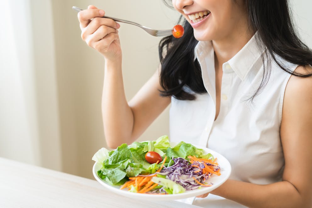 Happy woman eating salad