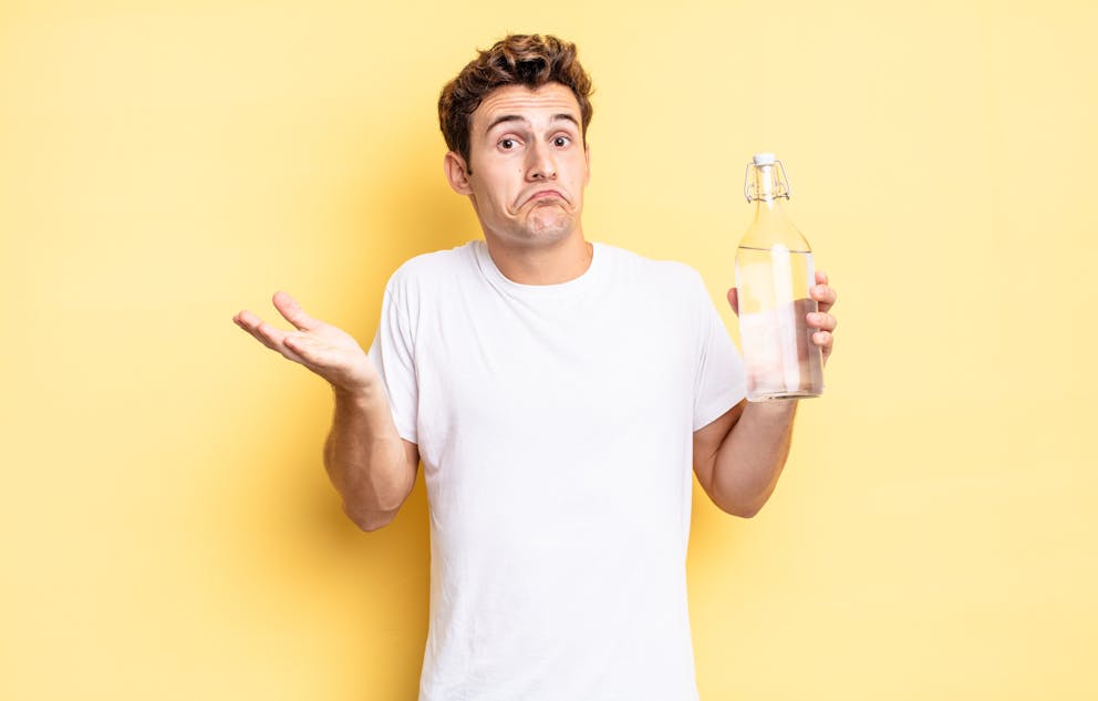 Confused man holding a water bottle