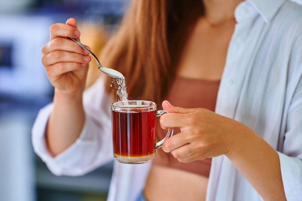 Healthy women pouring sugar substitute