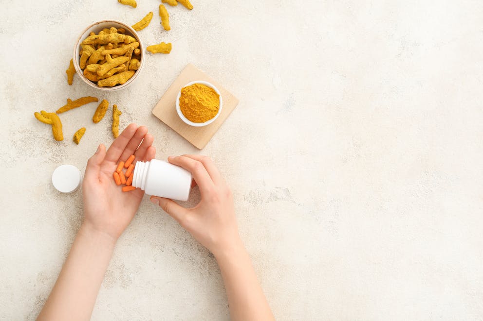 Hands with turmeric pills