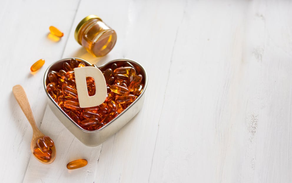 Vitamin D capsules on heart-shaped plate