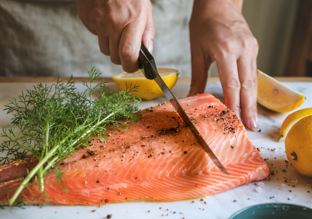 Cutting fresh seasoned salmon