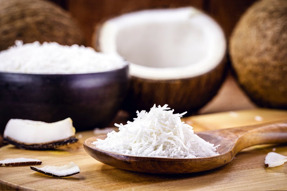 Shredded coconut on a wooden spoon