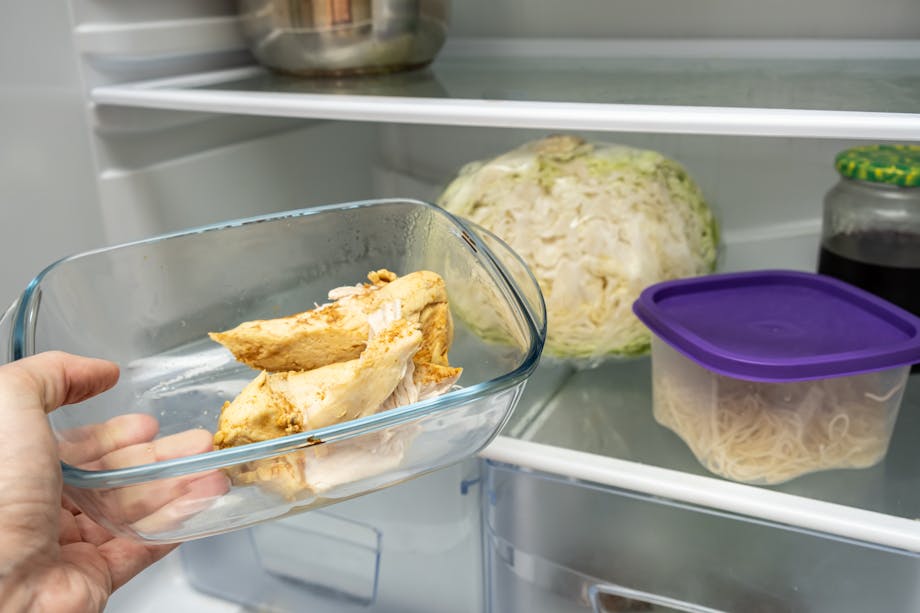 Placing baked chicken in the fridge