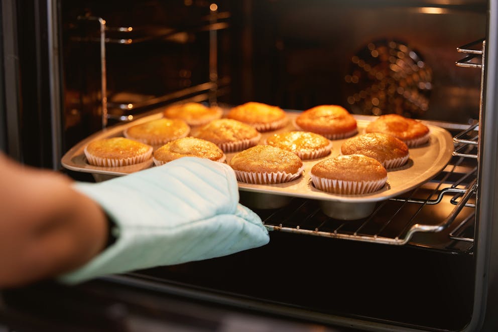 Placing muffins in the oven