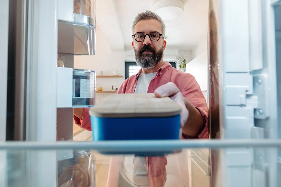 Man placing food in the fridge