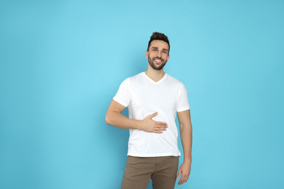 Young man touching his belly