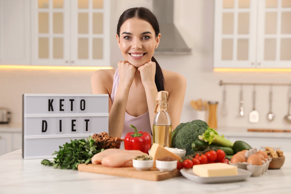 Woman behind a table with keto-friendly foods
