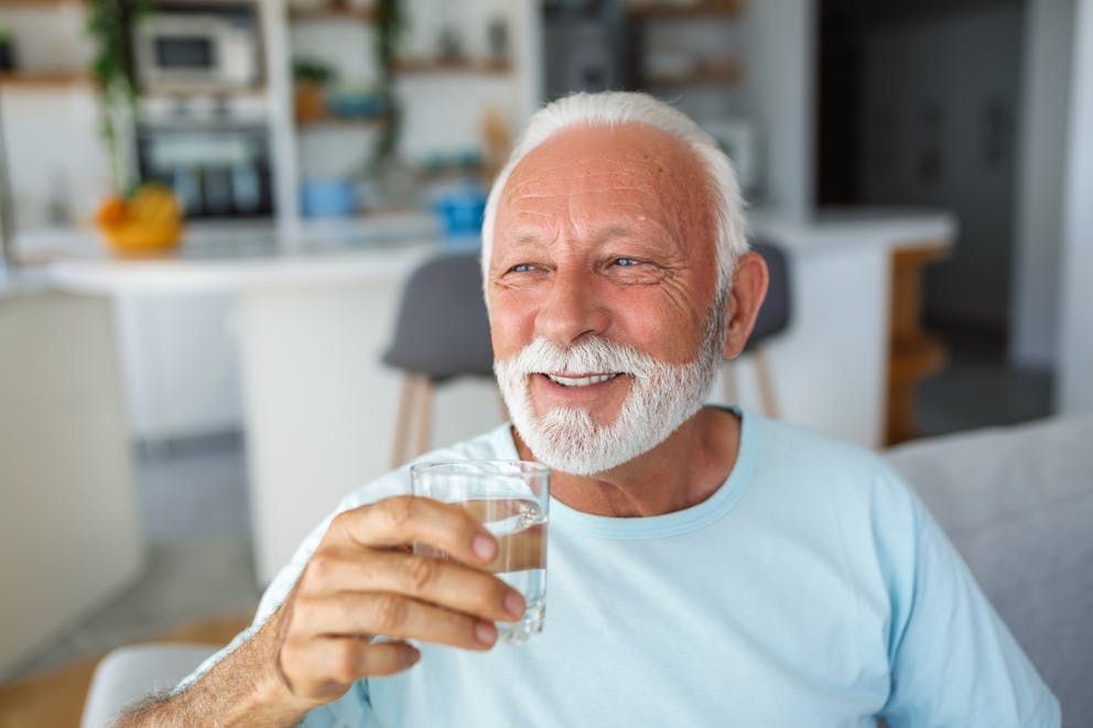 Senior man holding a glass of water