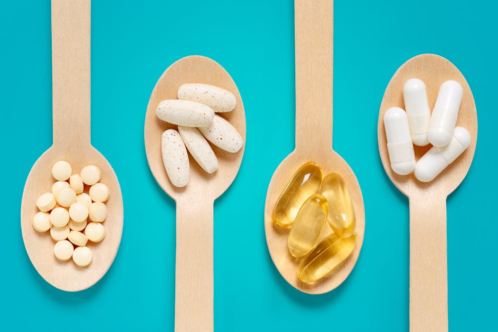 Various dietary supplements on wooden spoons