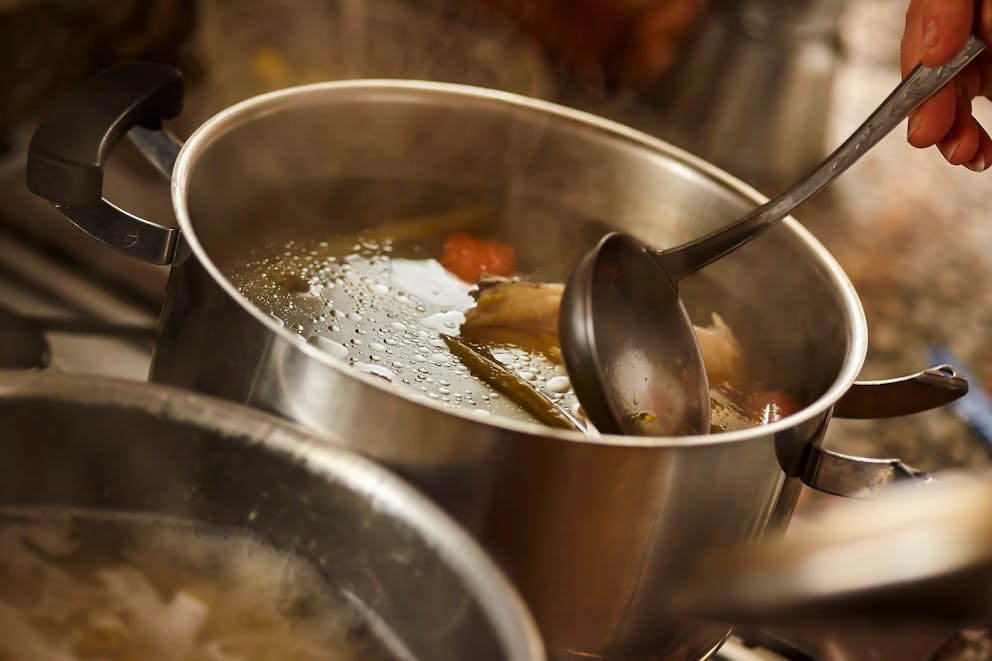 Stirring hot broth in a pot