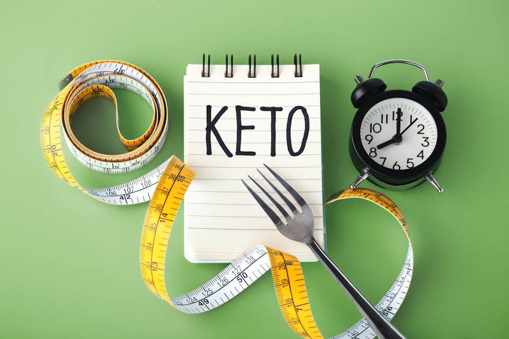 Keto on notebook, clock, and measuring tape