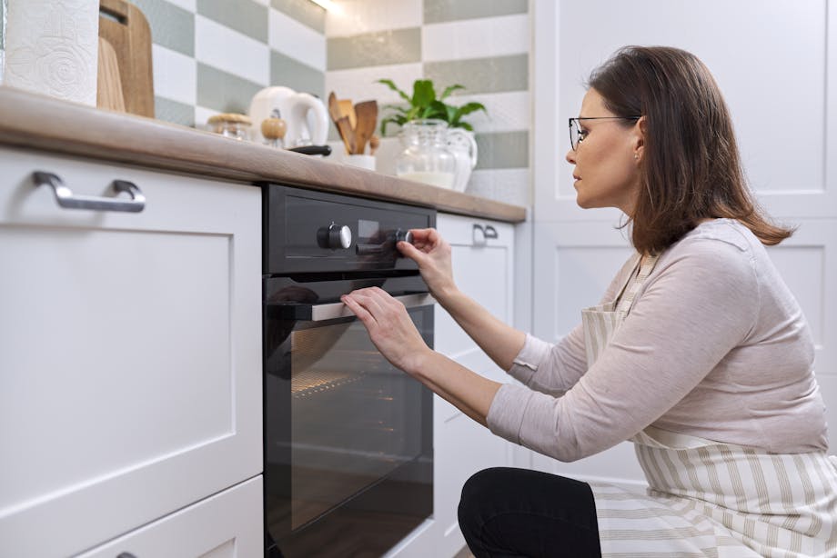 Woman setting oven temperature