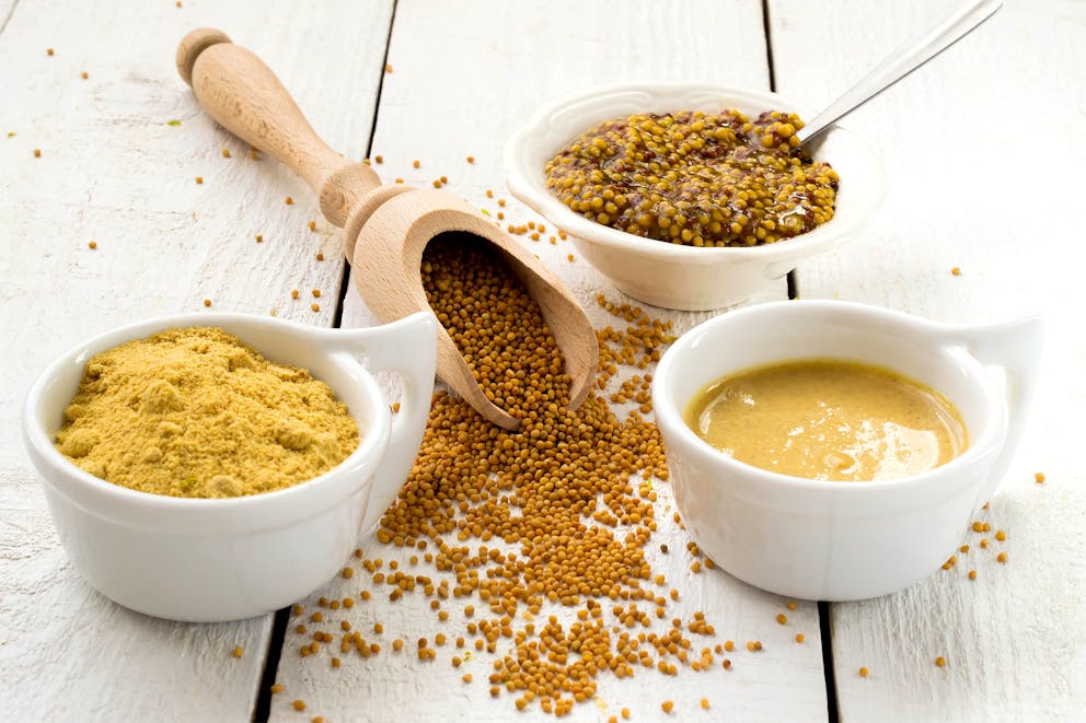 Yellow mustard seeds and mustard powder