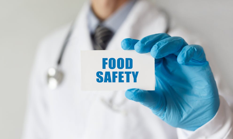 Doctor with gloves holding food safety sign