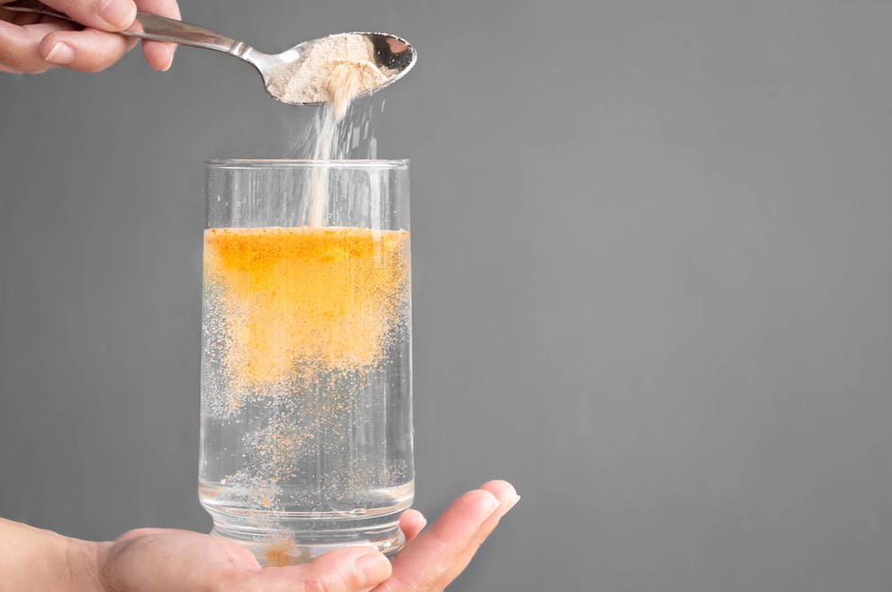 Orange electrolyte powder in a glass of water