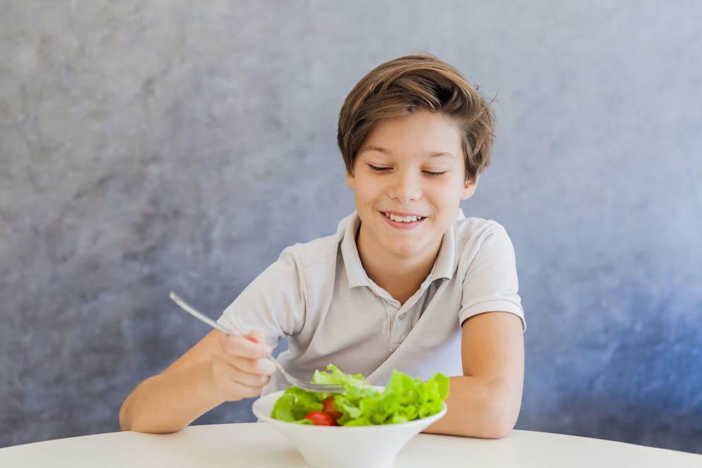 Teen boy eating a salad