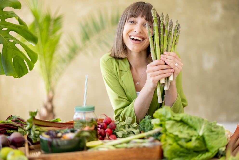 Happy woman holding asparagus