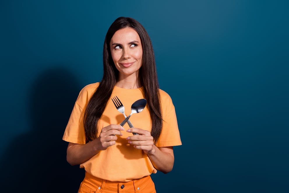 Thinking lady holding fork and spoon