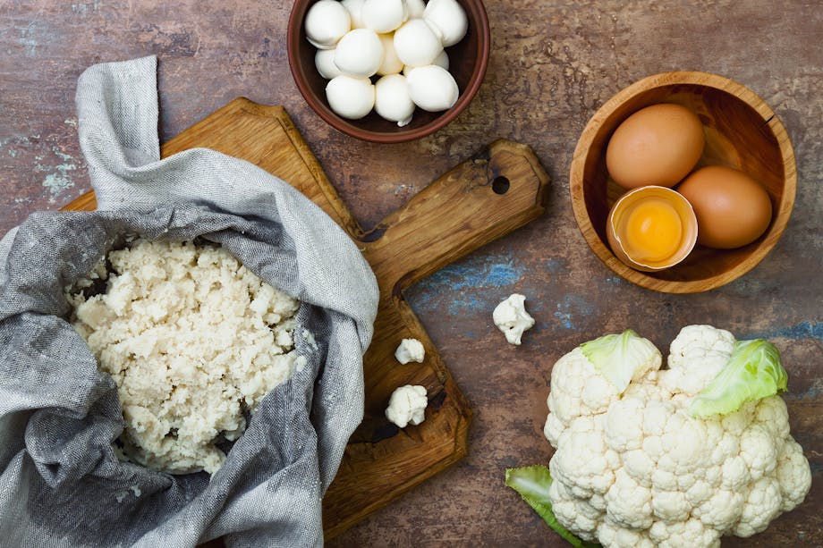 Preparing cauliflower pizza crust.