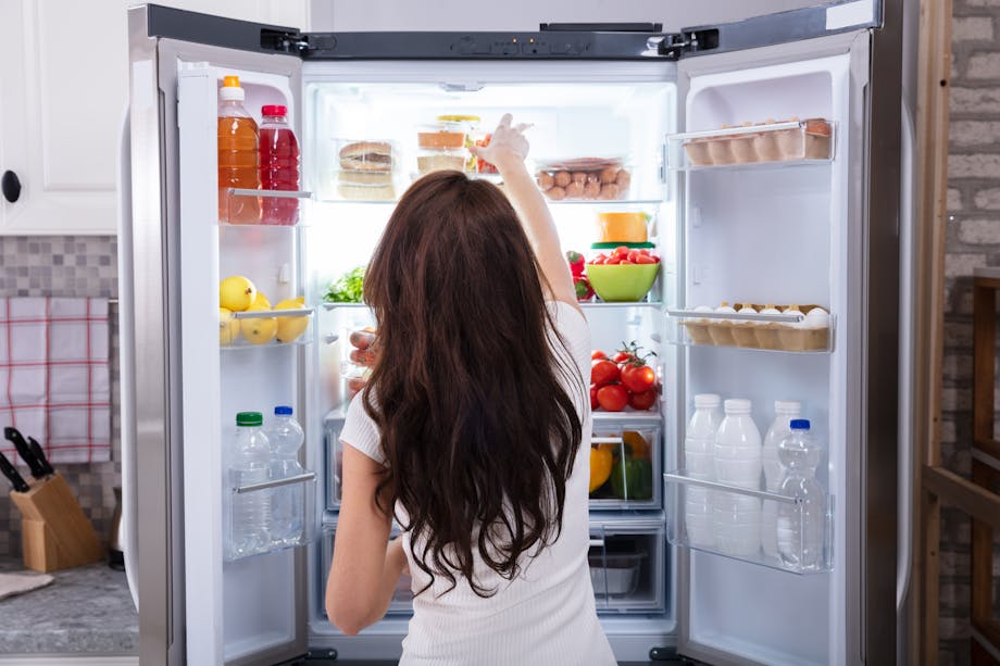 Woman taking food from fridge