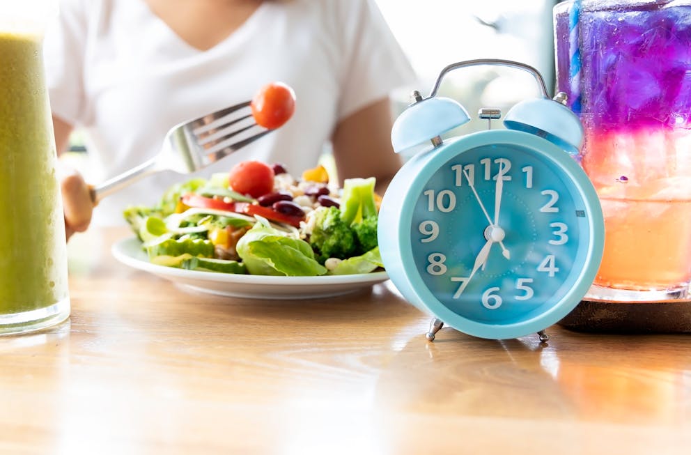 Blue clock in front of a salad plate
