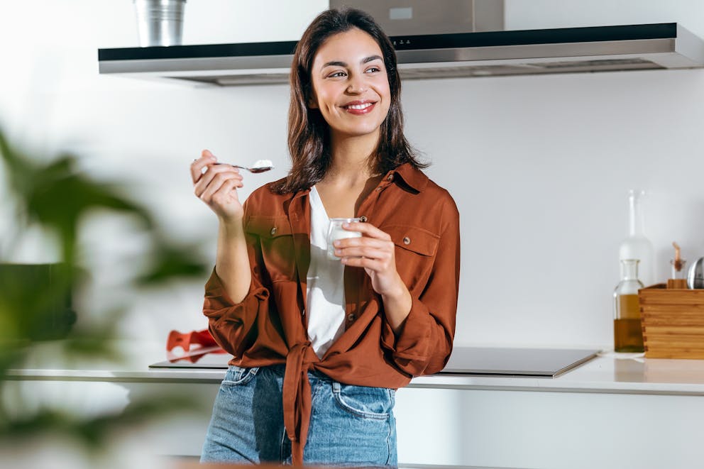 A healthy woman eating yogurt