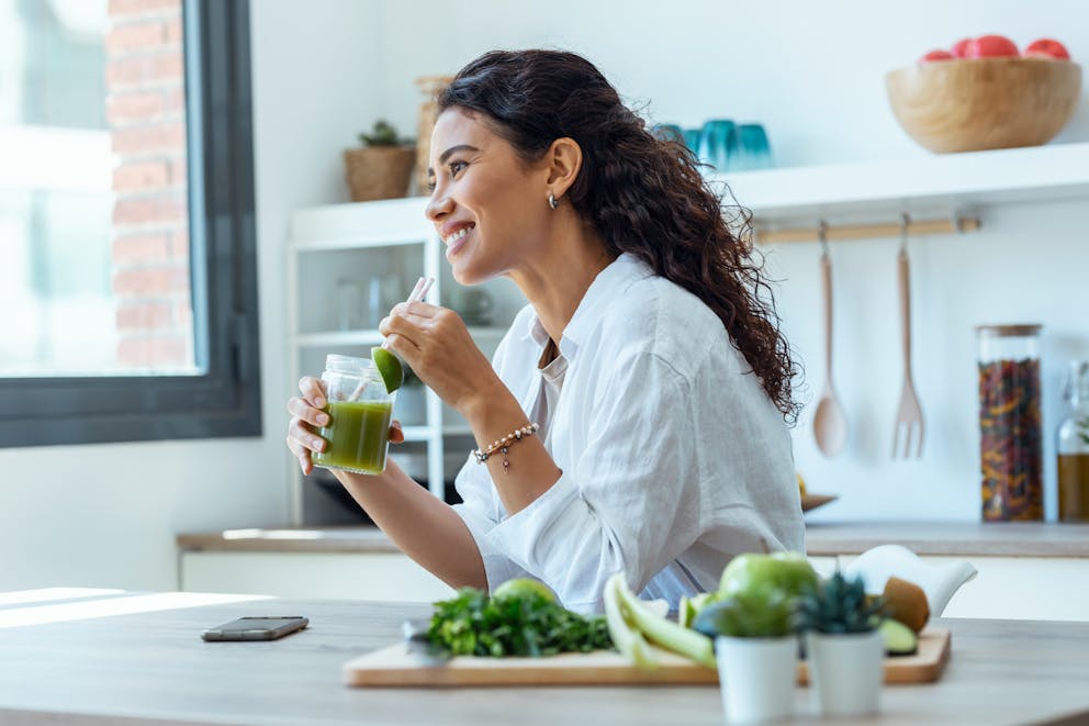 Woman drinking a green juice