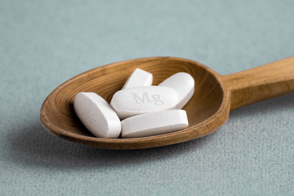 Magnesium supplement on wooden spoon