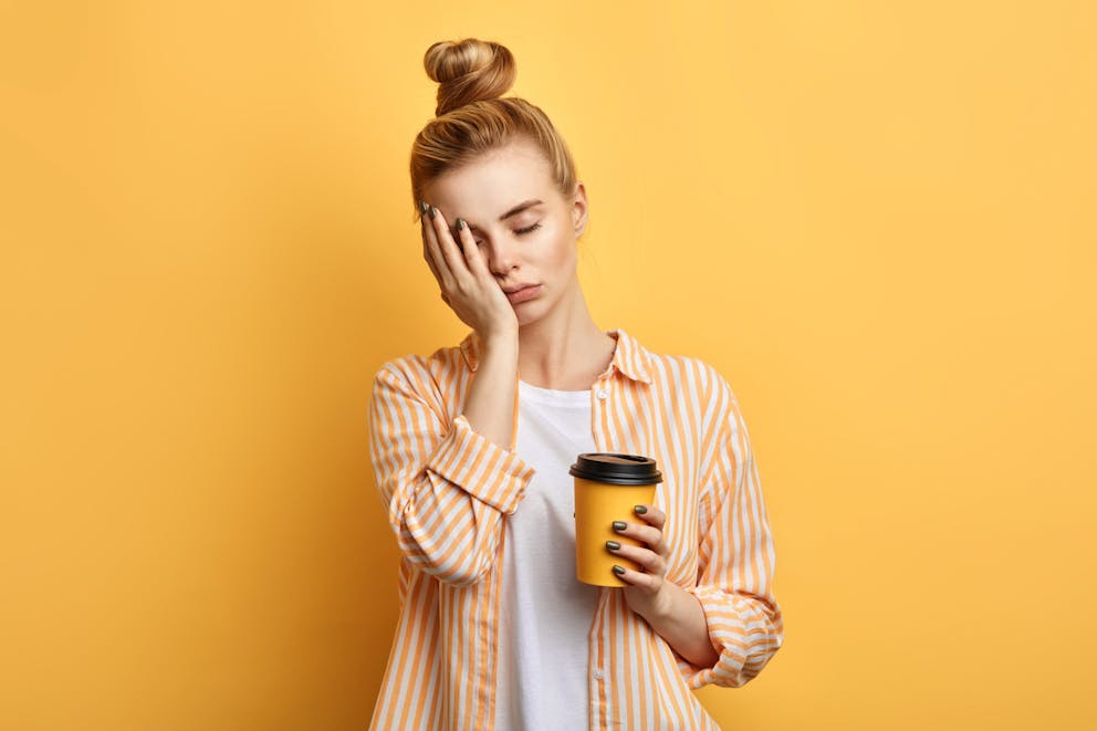 Tired woman holding cup