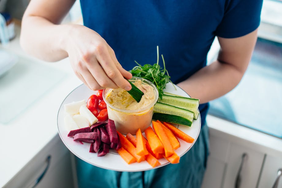 Dipping cucumber in hummus