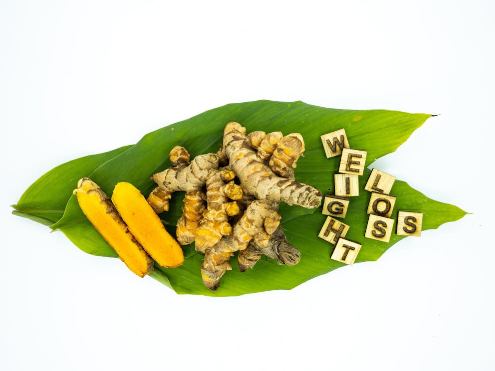 Turmeric root next to weight loss sign