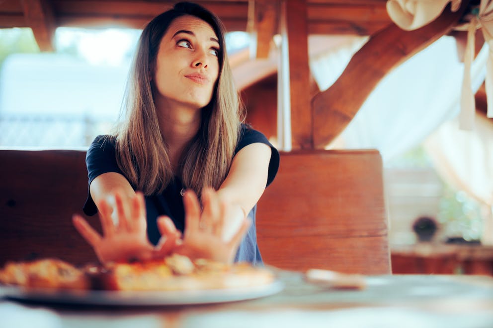 Woman refusing to eat pizza