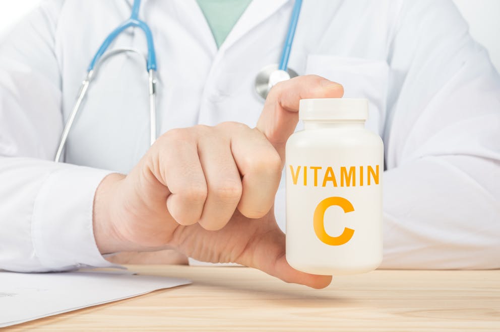 Doctor holding vitamin C supplement container