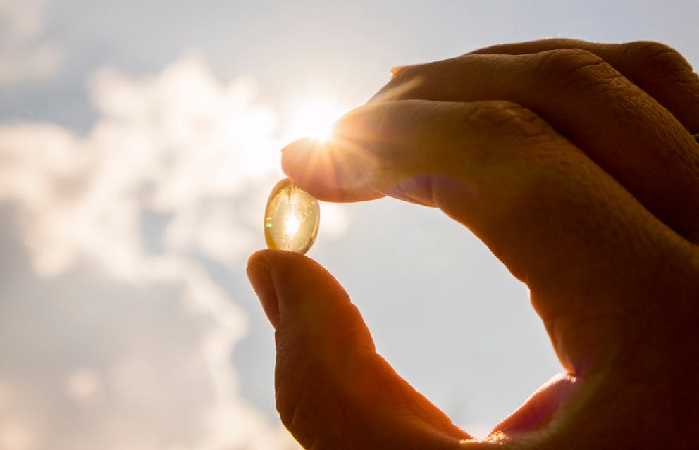 Vitamin D supplement held against the sun