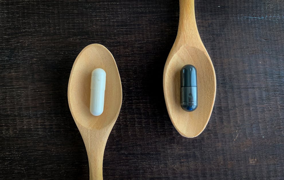 Different pills on wooden spoons