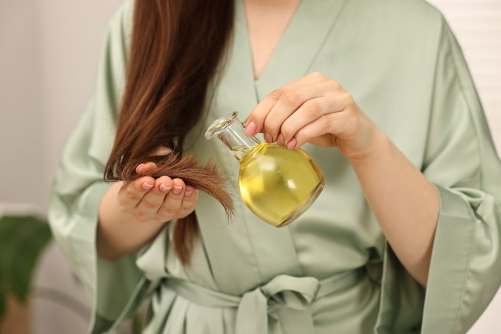 Woman applying oil on hair