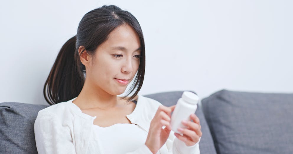 Woman reading supplement label