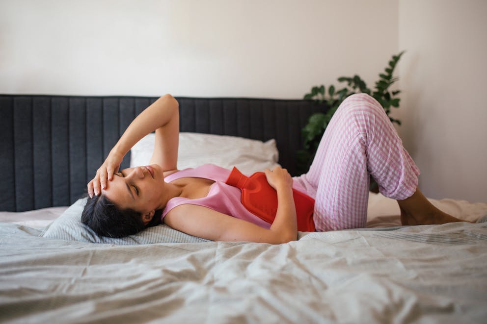 Woman in bed suffering from menstrual pain