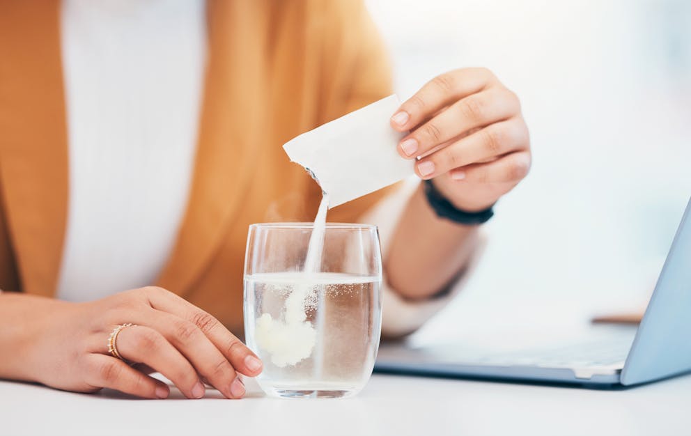 Women pouring supplement into water