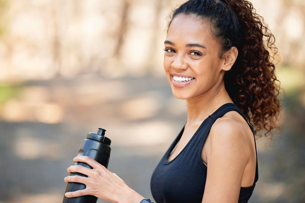 Happy woman drinking electrolyte beverage