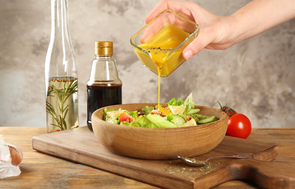 Mustard dressing poured onto a salad