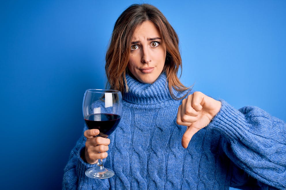 Woman thumbs down to a glass of wine