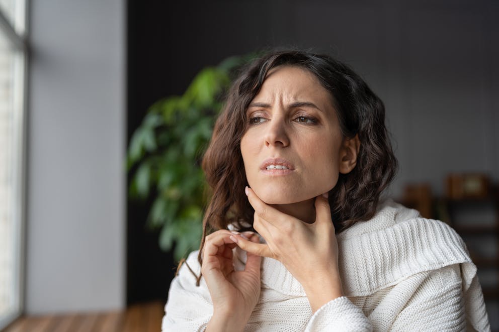 Woman concerned grabbing her neck