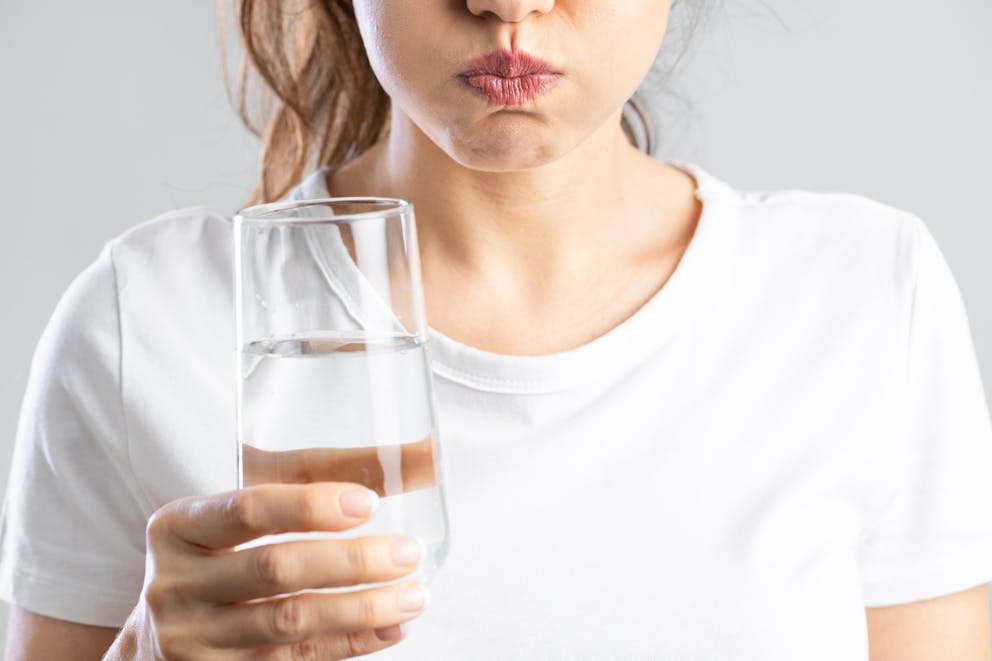Woman holding water in her mouth